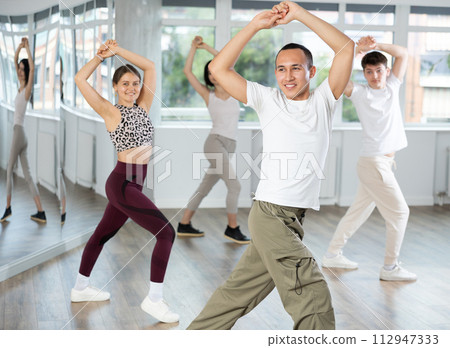 Smiling young Asian dancer practicing flamenco in dance studio Smiling young Asian dancer practicing flamenco in dance studio 112947333
