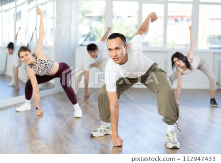 Expressive Asian guy honing hip-hop dance moves in studio 112947433