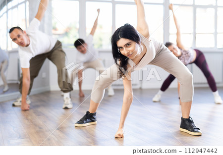 Girl with team of young like-minded people learn to dance modern dances 112947442