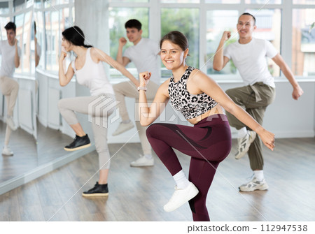 Girl with team of young like-minded people learn to dance modern dances 112947538