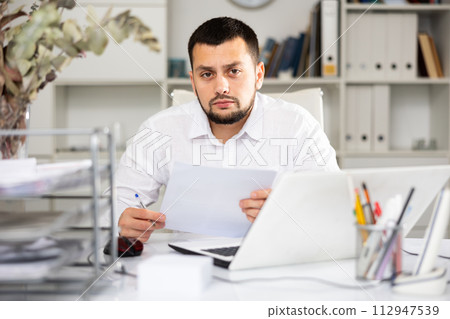 Man bookkeeper doing paperwork in office 112947539