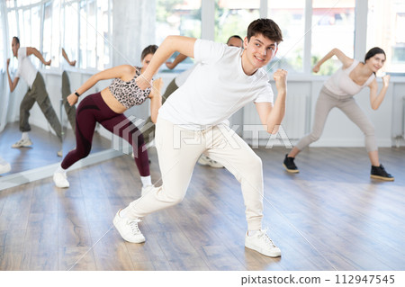 Guy with team of young like-minded people learn to dance modern dances 112947545