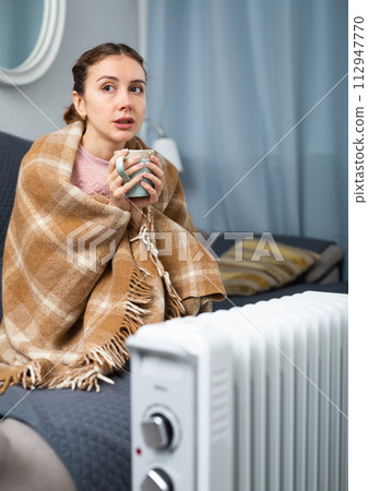 Woman feeling cold at home in winter Woman feeling cold at home in winter 112947770