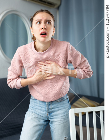 Woman suffering from chest pain at home Woman suffering from chest pain at home 112947794