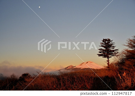 The lingering moon over Mt. Asama at sunrise from the Karuizawa Old Usui Pass viewing platform The lingering moon over Mt. Asama at sunrise from the Karuizawa Old Usui Pass viewing platform 112947817