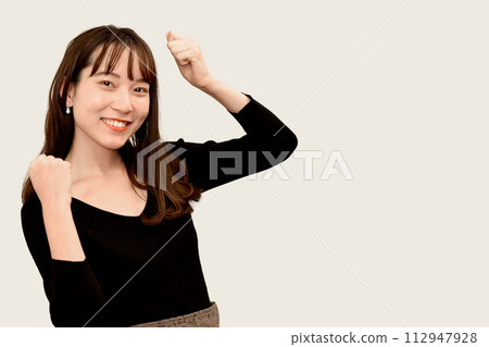 Young Asian woman doing a fist pump Young Asian woman doing a fist pump 112947928