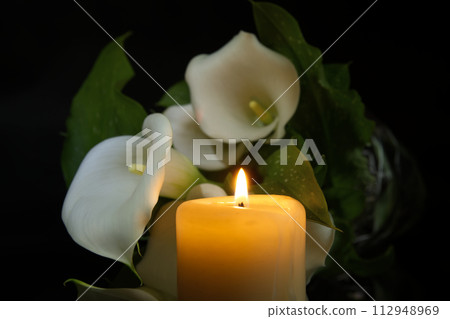 Burning wax candle in close up and white calla lily 112948969