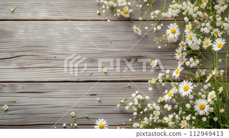 Daisies and gypsophila flowers on grey wooden table background. Top view. Copy space Daisies and gypsophila flowers on grey wooden table background. Top view. Copy space 112949413