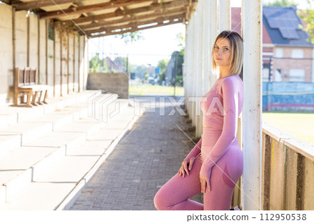 Athletic Poise: Confident Woman in Fitness Gear at Urban Gym 112950538