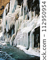 Icicles waterfall on the edge of the river. 112950954