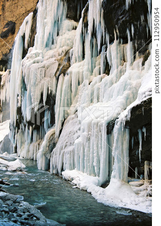Icicles waterfall on the edge of the river. Icicles waterfall on the edge of the river. 112950954