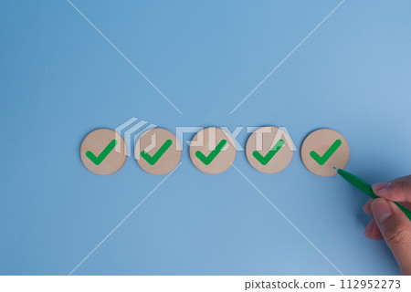 hand holding pen check mark on blue background. Business quality target strategy marketing concept. 112952273