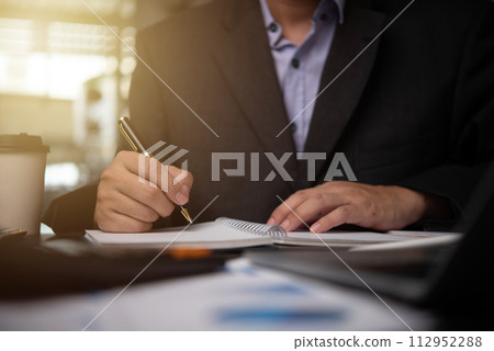 man hands with pen writing on notebook in the office.learning, education and work.writes goals, plans, make to do and wish list on desk. man hands with pen writing on notebook in the office.learning, education and work.writes goals, plans, make to do and wish list on desk. 112952288