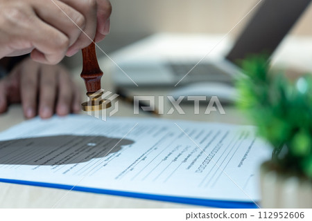 Man stamping approval of work finance banking or investment marketing documents on desk... Man stamping approval of work finance banking or investment marketing documents on desk... 112952606