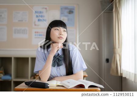 Short sleeves of a high school girl studying in the classroom. An image of worrying and thinking because studying is difficult. Short sleeves of a high school girl studying in the classroom. An image of worrying and thinking because studying is difficult. 112953011