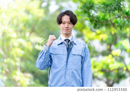 戶外穿工作服的男人，新鮮的綠色植物，拳頭泵 112953388