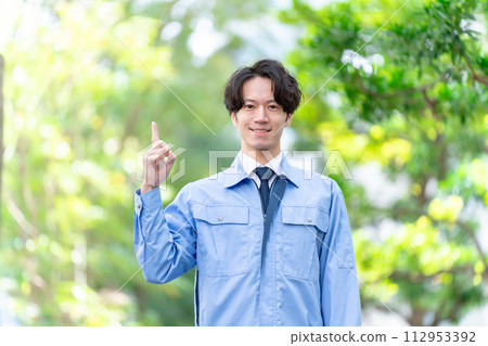 Men in work clothes, outdoor fresh green pointing Men in work clothes, outdoor fresh green pointing 112953392