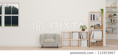 A minimalist white living room features a grey armchair, shelves, a white wall, and a parquet floor. 112953667