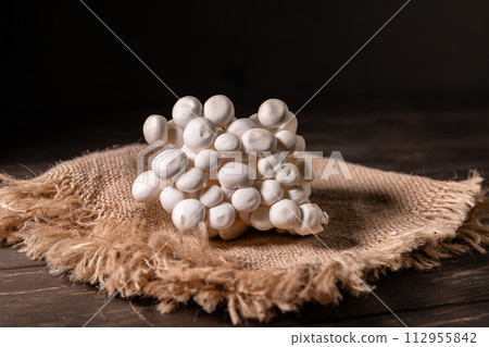 Closeup of a bunch of shimeji mushrooms on canvas and wooden background, with copy space, superfood, a type of delicious oyster mushroom, healthy food 112955842