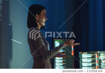 asian woman developer presentation about coding software data with devops team at night in office 112956149