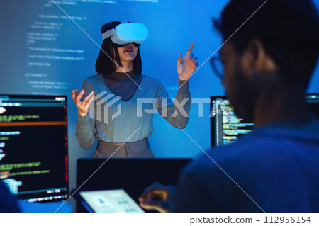 asian and Indian developer devops team testing  virtual reality coding and presentation  with ai prompt  at night in office 112956154