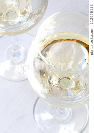 An image of a toast with two wine glasses filled with white wine 112956158