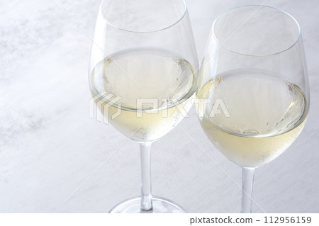An image of a toast with two wine glasses filled with white wine An image of a toast with two wine glasses filled with white wine 112956159