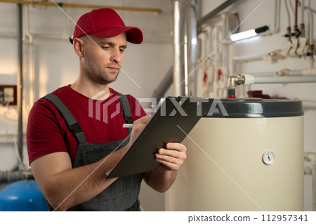 Skilled Technician Inspecting Industrial Boiler in Factory Setting During Daytime Shift Skilled Technician Inspecting Industrial Boiler in Factory Setting During Daytime Shift 112957341
