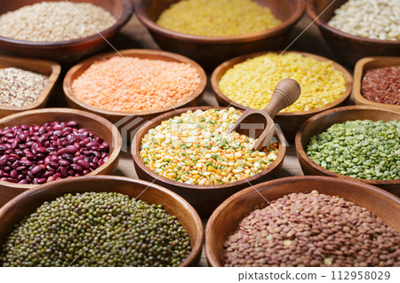 bowls of legumes, lentils, chickpeas, rice and beans on wooden background 112958029