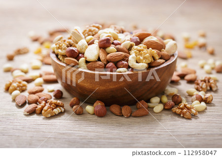 bowl of mixed nuts on wooden table bowl of mixed nuts on wooden table 112958047