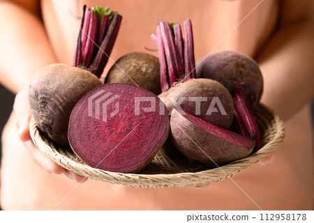 Fresh beetroot in basket holding by woman hand Fresh beetroot in basket holding by woman hand 112958178