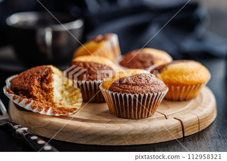 Close Up of a Muffins on cutting board on black table. 112958321