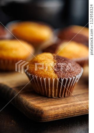 Close Up of a Muffins on cutting board on black table. Close Up of a Muffins on cutting board on black table. 112958324