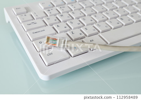 Internet wire lies on a white computer keyboard Internet wire lies on a white computer keyboard 112958489