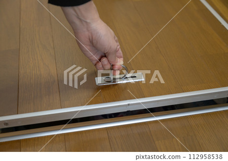 女人的手打開和關閉地板下的儲藏室 女人的手打開和關閉地板下的儲藏室 112958538