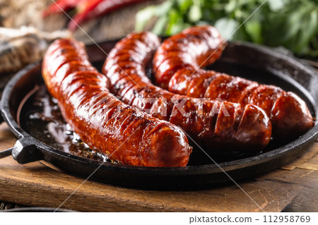 Sausages fried with spices bbq sauce and herbs - Close up 112958769