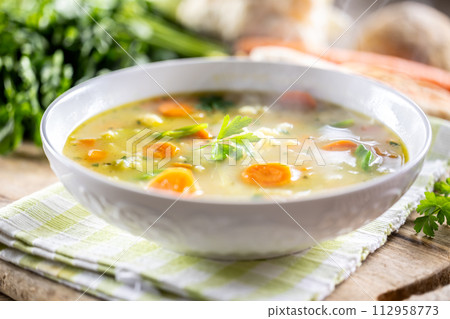 Spring vegetable soup with chopped and grated root vegetables, seasoned with yeast. Healthy vegetable vegetarian food 112958773