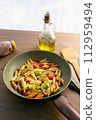 Colorful Pasta Dish in Pan with Olive Oil and Wooden Spatula 112959494