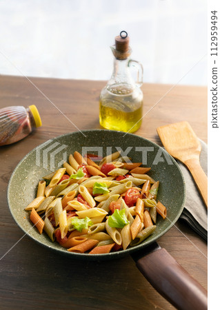 Colorful Pasta Dish in Pan with Olive Oil and Wooden Spatula Colorful Pasta Dish in Pan with Olive Oil and Wooden Spatula 112959494