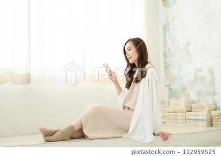 坐和觀看智能手機的婦女 112959525