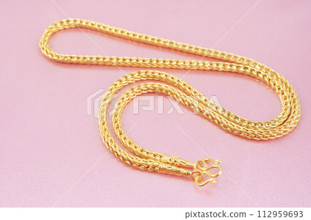A Gold Necklace on pink silk background. A Gold Necklace on pink silk background. 112959693