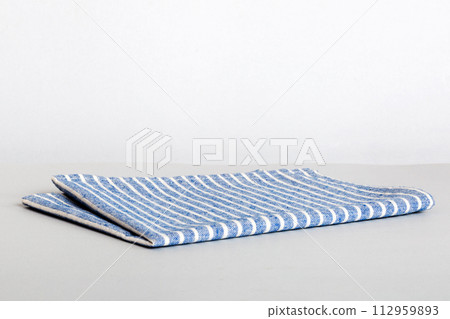 top view with blue kitchen napkin isolated on table background. Folded cloth for mockup with copy space, Flat lay. Minimal style top view with blue kitchen napkin isolated on table background. Folded cloth for mockup with copy space, Flat lay. Minimal style 112959893