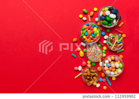 different colored round candy in bowl and jars. Top view of large variety sweets and candies with copy space 112959902