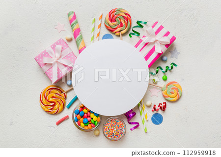 Flat lay holiday composition. Paper blank, lollipop, birthday decorations on Colored background. Top view, copy space for text 112959918
