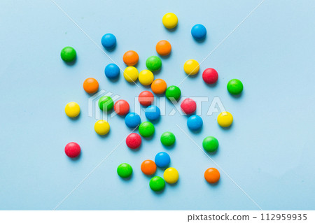Mixed collection of colorful candy, on colored background. Flat lay, top view. frame of colorful chocolate coated candy 112959935