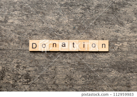 donation word written on wood block. donation text on table, concept donation word written on wood block. donation text on table, concept 112959983
