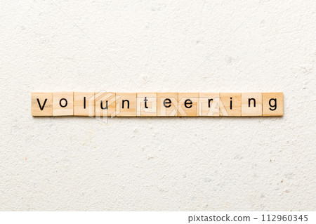 volunteering word written on wood block. volunteering text on table, concept volunteering word written on wood block. volunteering text on table, concept 112960345