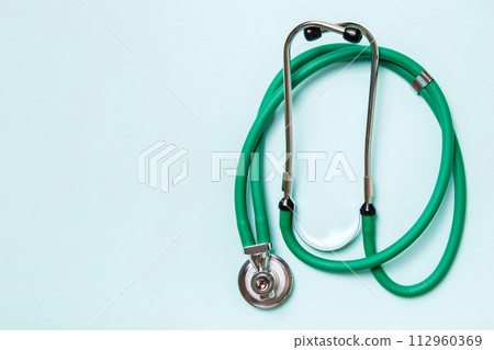 Top view of green medical stethoscope on colorful background with copy space. Medicine equipment concept 112960369