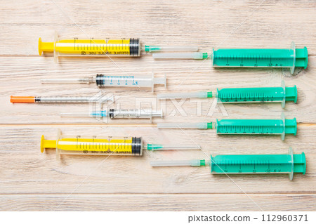 Top view of many syringes and one insulin syringe prepared for injection at wooden background. Treatment concept with copy space Top view of many syringes and one insulin syringe prepared for injection at wooden background. Treatment concept with copy space 112960371