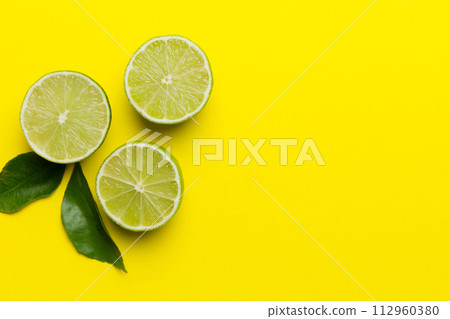 Lime fruits with green leaf and cut in half slice isolated on white background. Top view. Flat lay with copy space Lime fruits with green leaf and cut in half slice isolated on white background. Top view. Flat lay with copy space 112960380